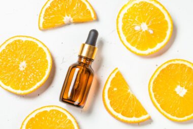 Vitamin C skincare serum next to orange slices